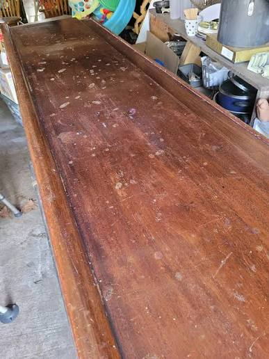A close view of the Chateau's old wooden bar counter, worn and marked from decades of use.