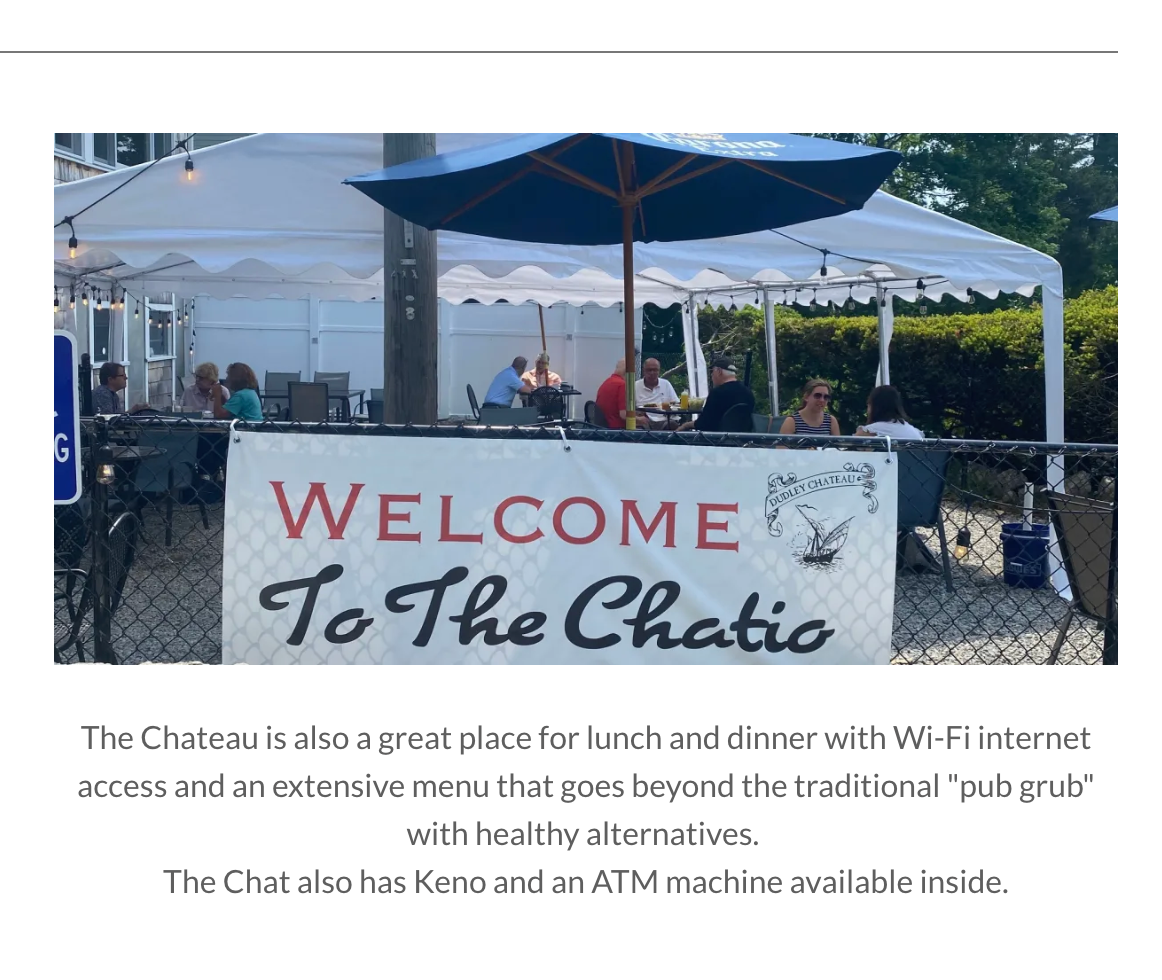 The Chatio, the Dudley Chateau's outdoor patio: tented seating with umbrellas, string lights and a welcome banner along a chain-link fence.
